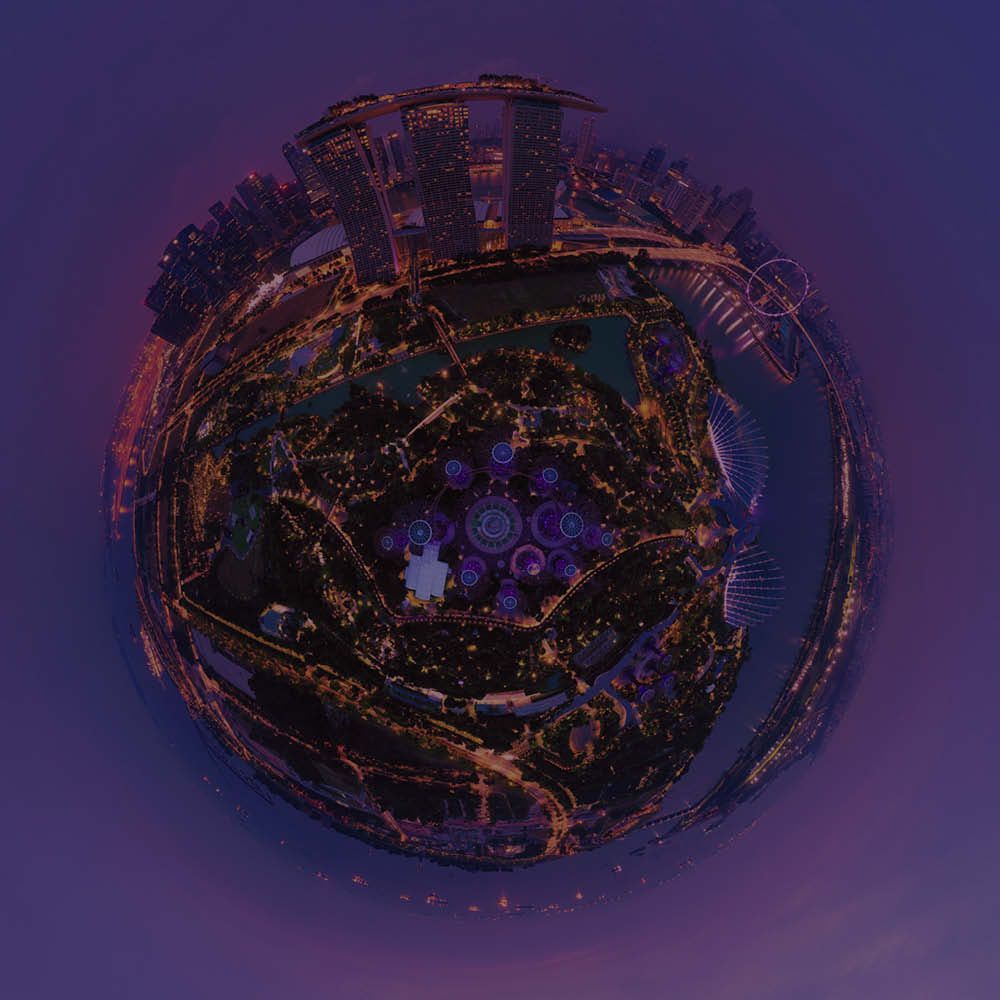Nighttime panoramic view of Singapore cityscape in a spherical format, lit with orange and white lights against a purple sky.