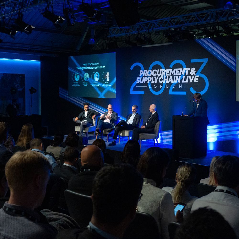 A group of people sitting in front of a stage that says procurement & supply chain live