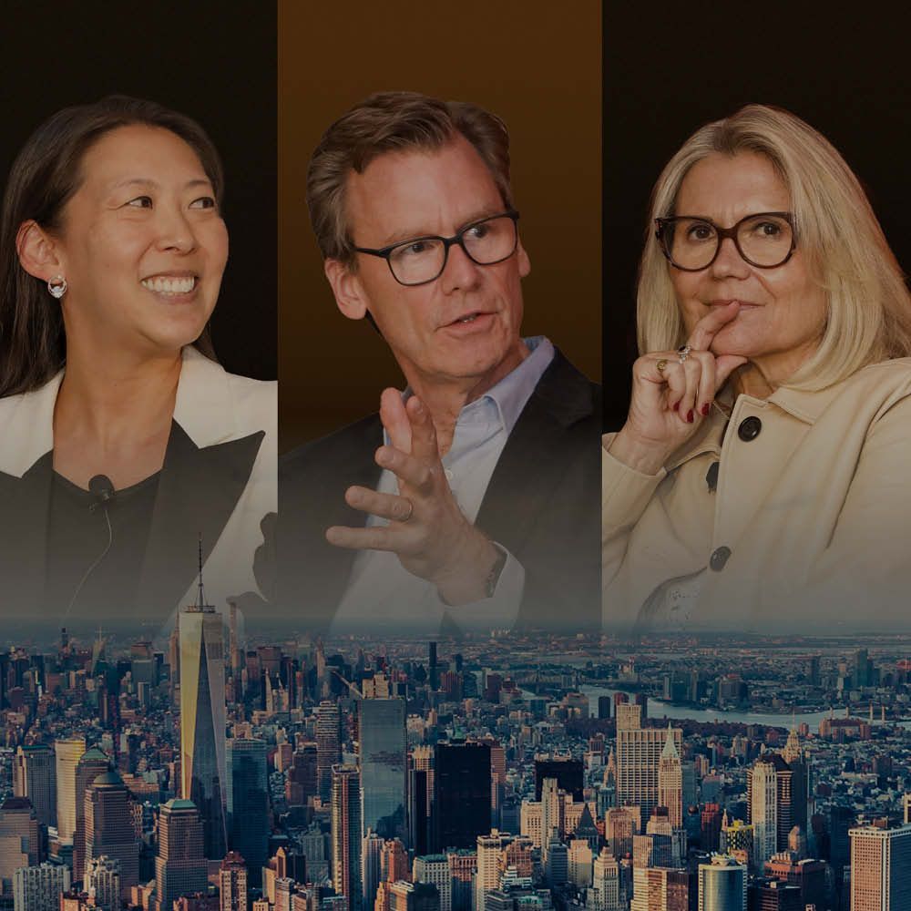 An aerial view of a city at night with a lot of buildings and a river in the foreground.