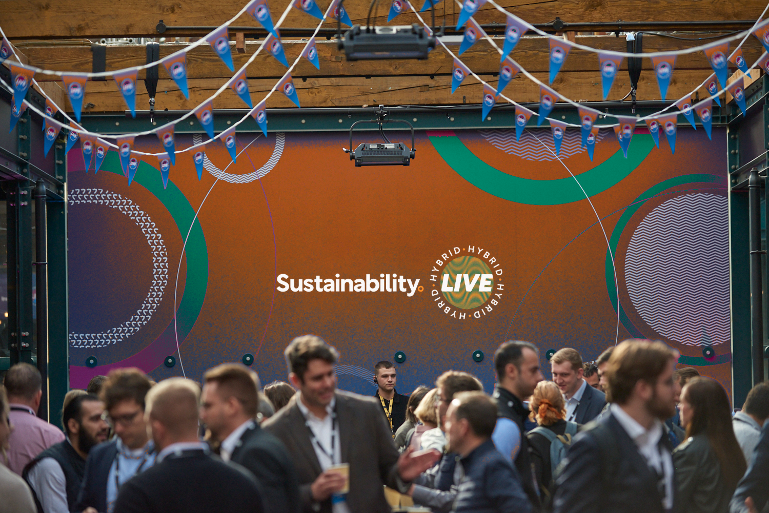 A group of people standing in front of a sign that says sustainability live