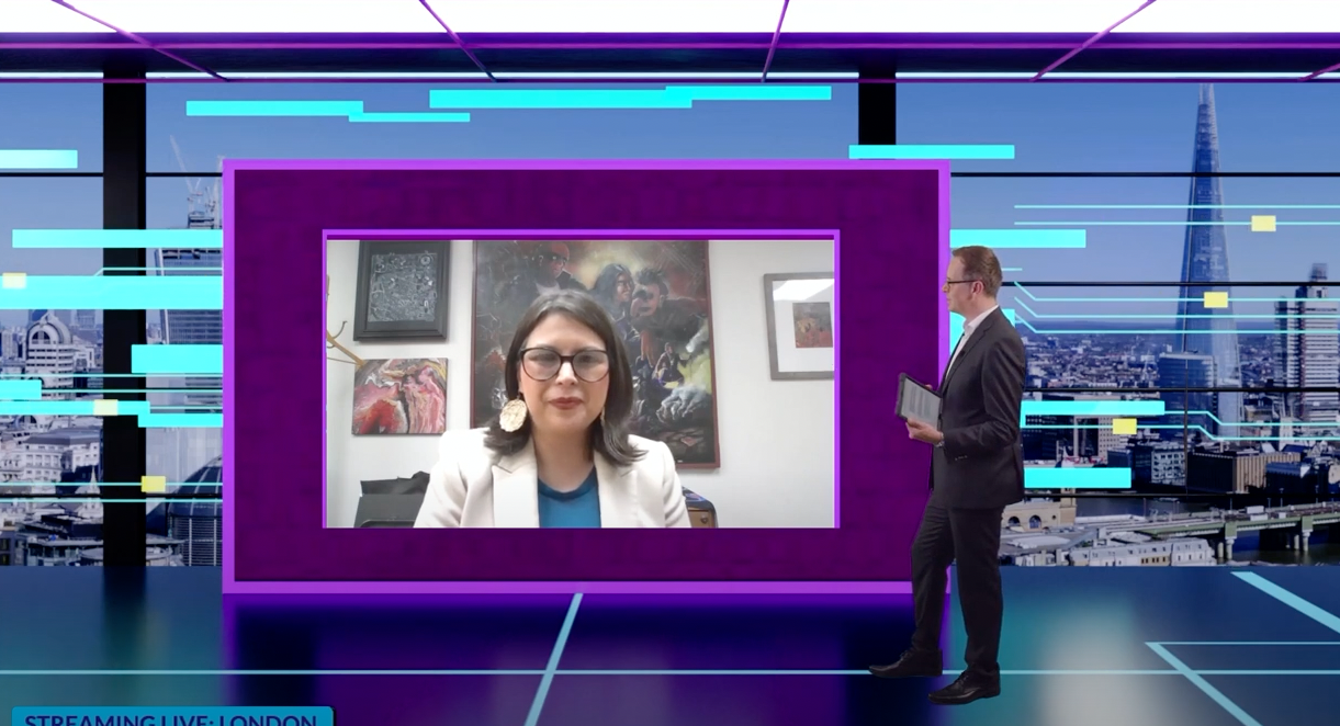 A woman is sitting in front of a man in a suit in a purple frame.