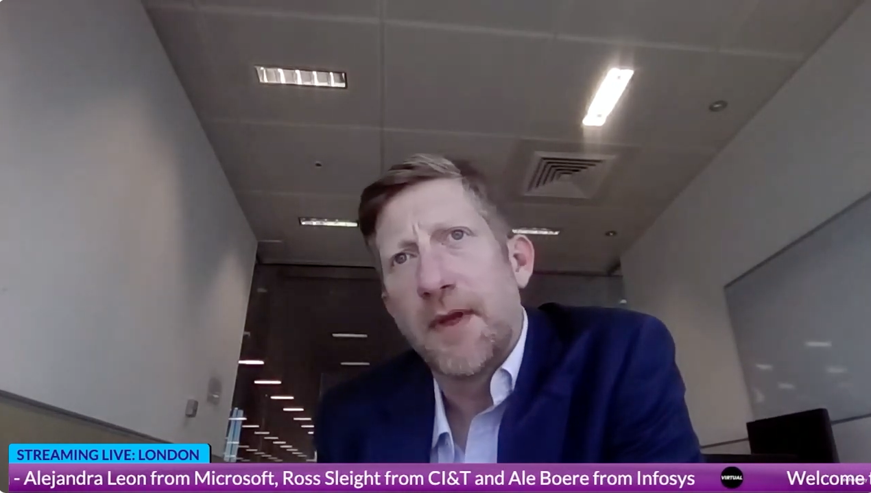 A man in a suit is sitting in front of a computer screen.