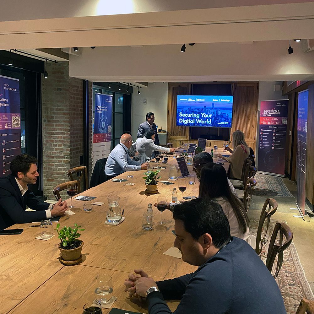 A group of people are sitting around a long wooden table