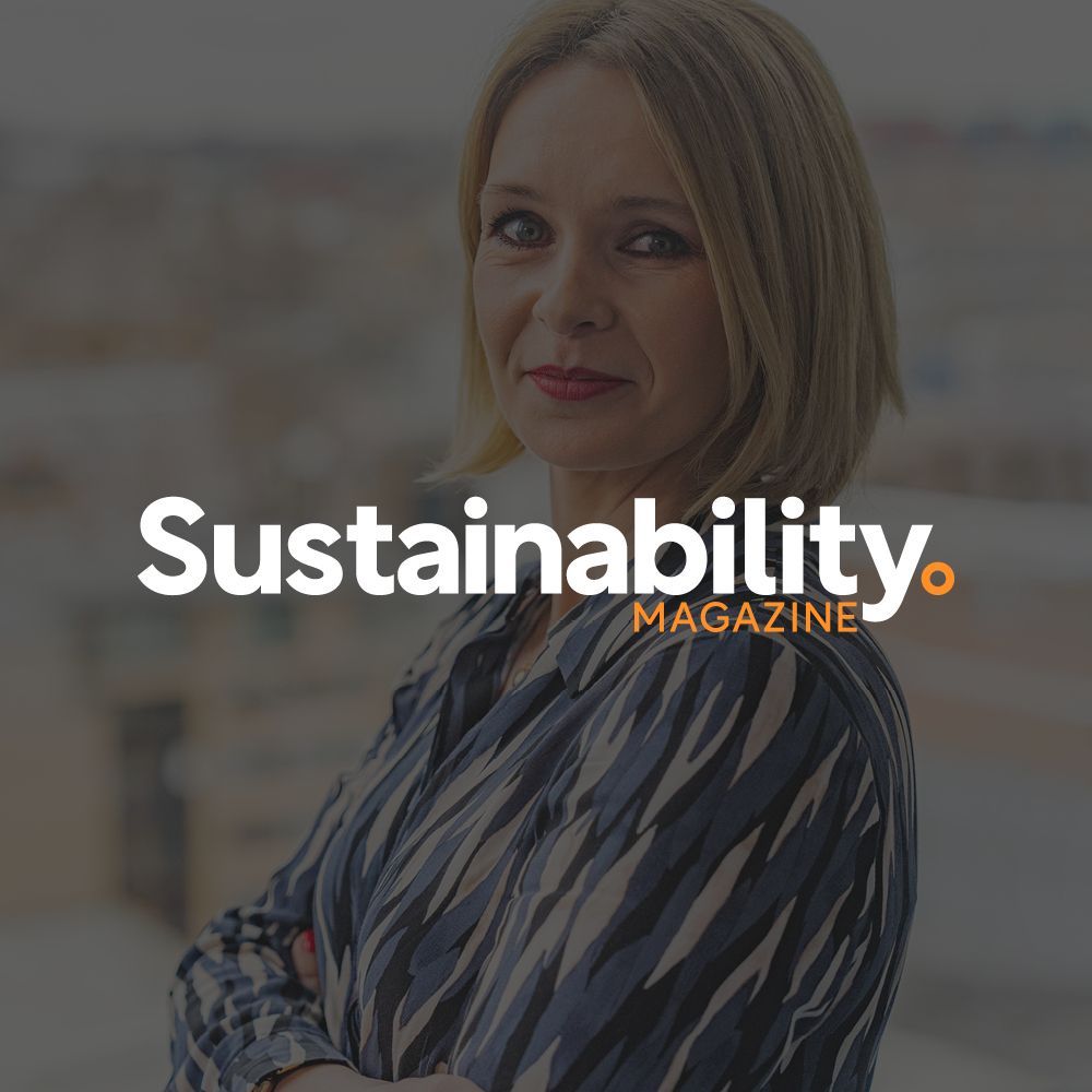 A woman is standing in front of a sustainability magazine logo