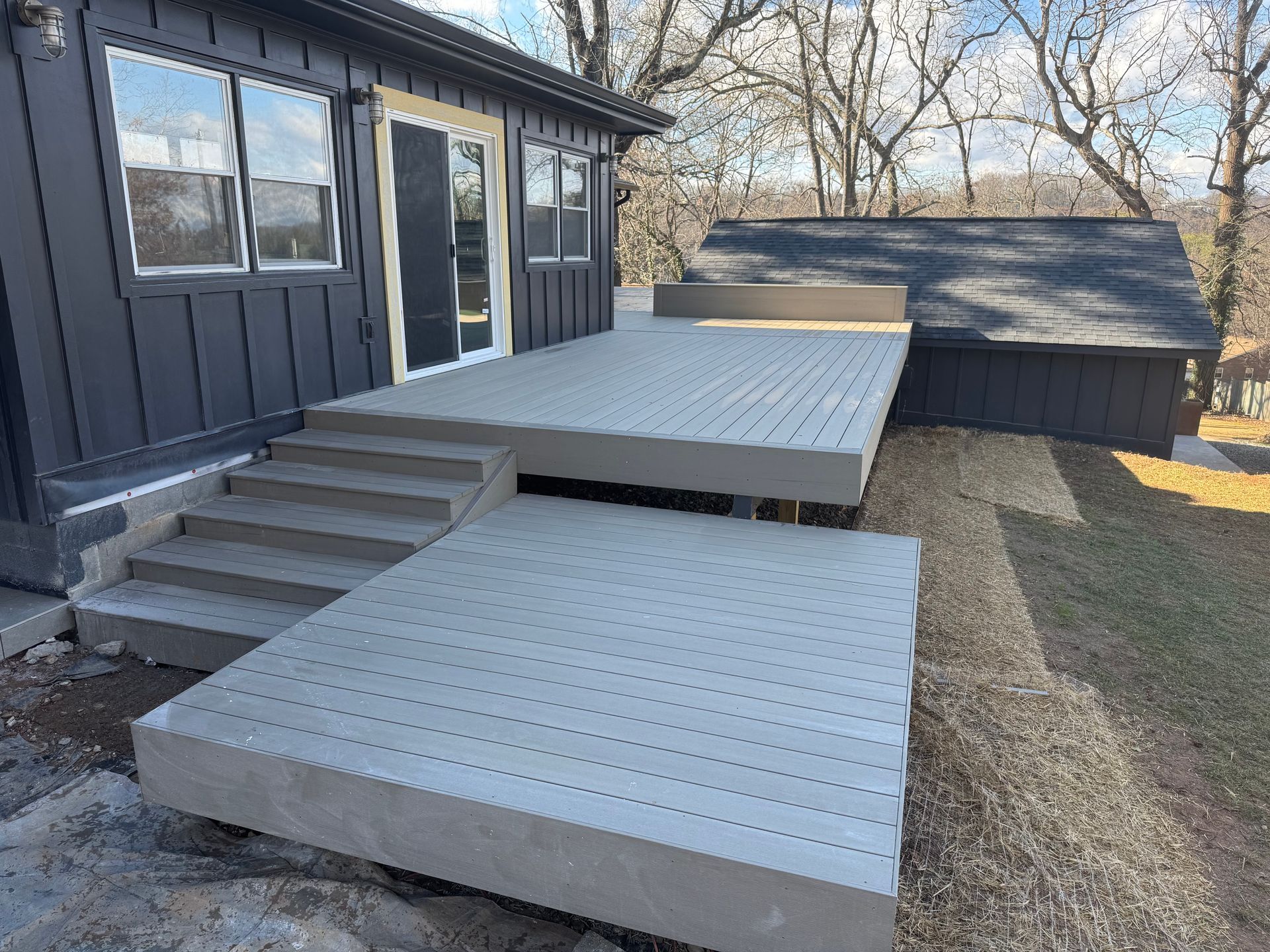A house with a large deck and stairs in front of it.