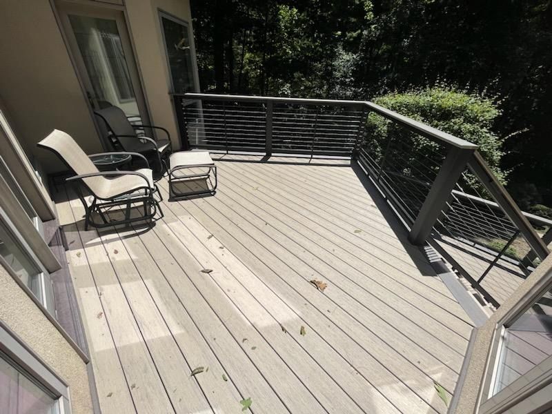 A deck with chairs and ottomans on it