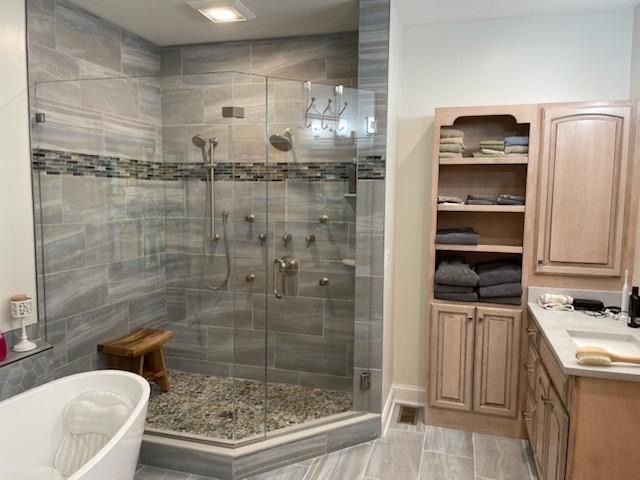 A bathroom with a walk in shower and a bathtub.