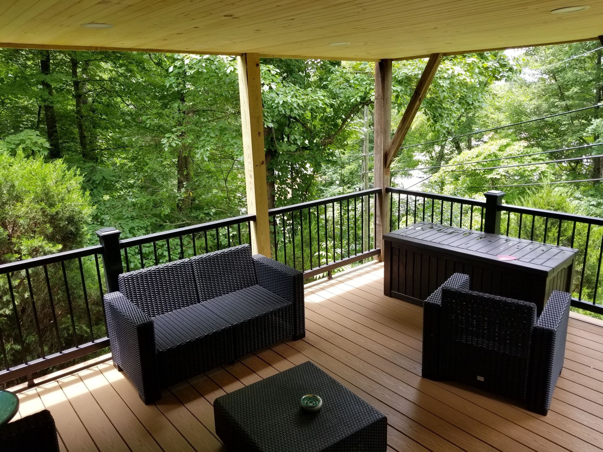 A deck with a couch , chairs and a table