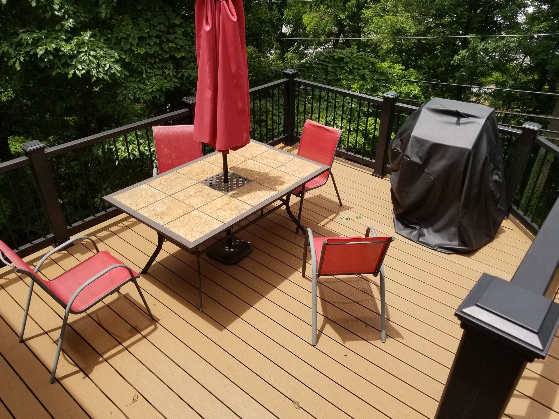 A deck with a table and chairs and an umbrella