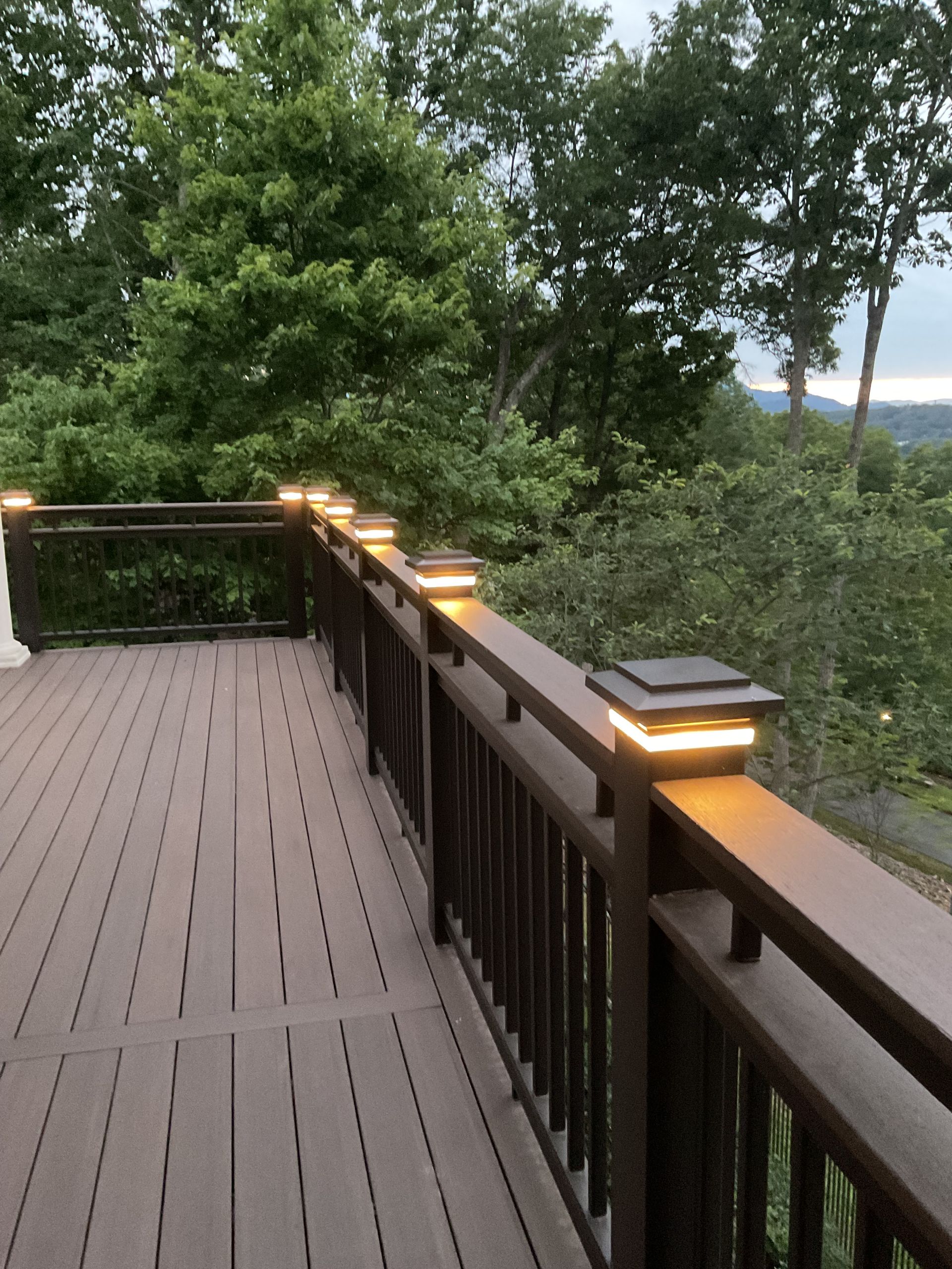 A wooden deck with a table and chairs and a hot tub