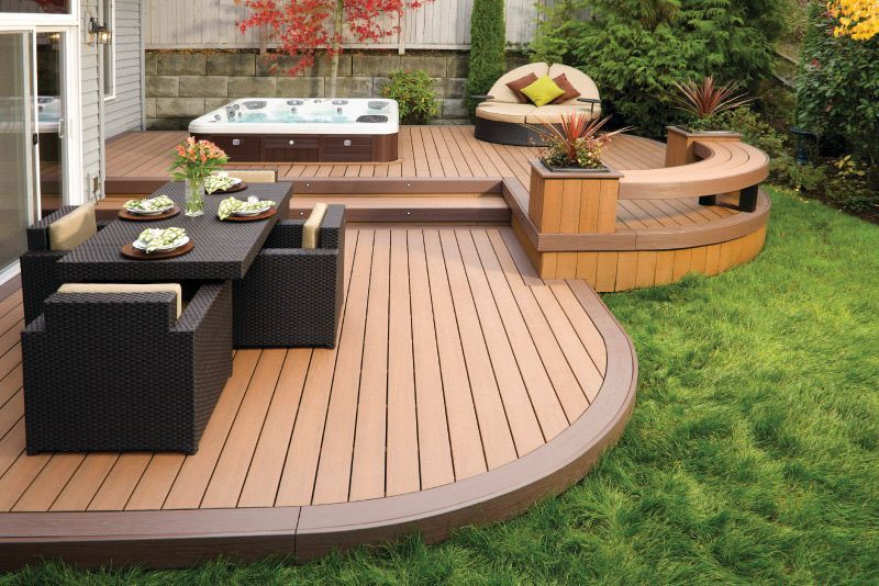 A wooden deck with a table and chairs and a hot tub