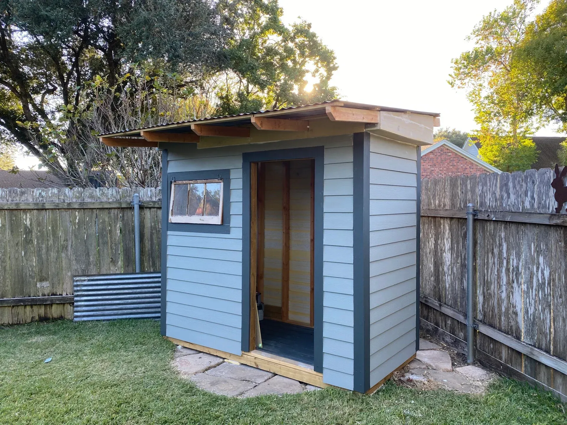 Ladder against a decaying tree trunk, tools attached, under a blue sky.