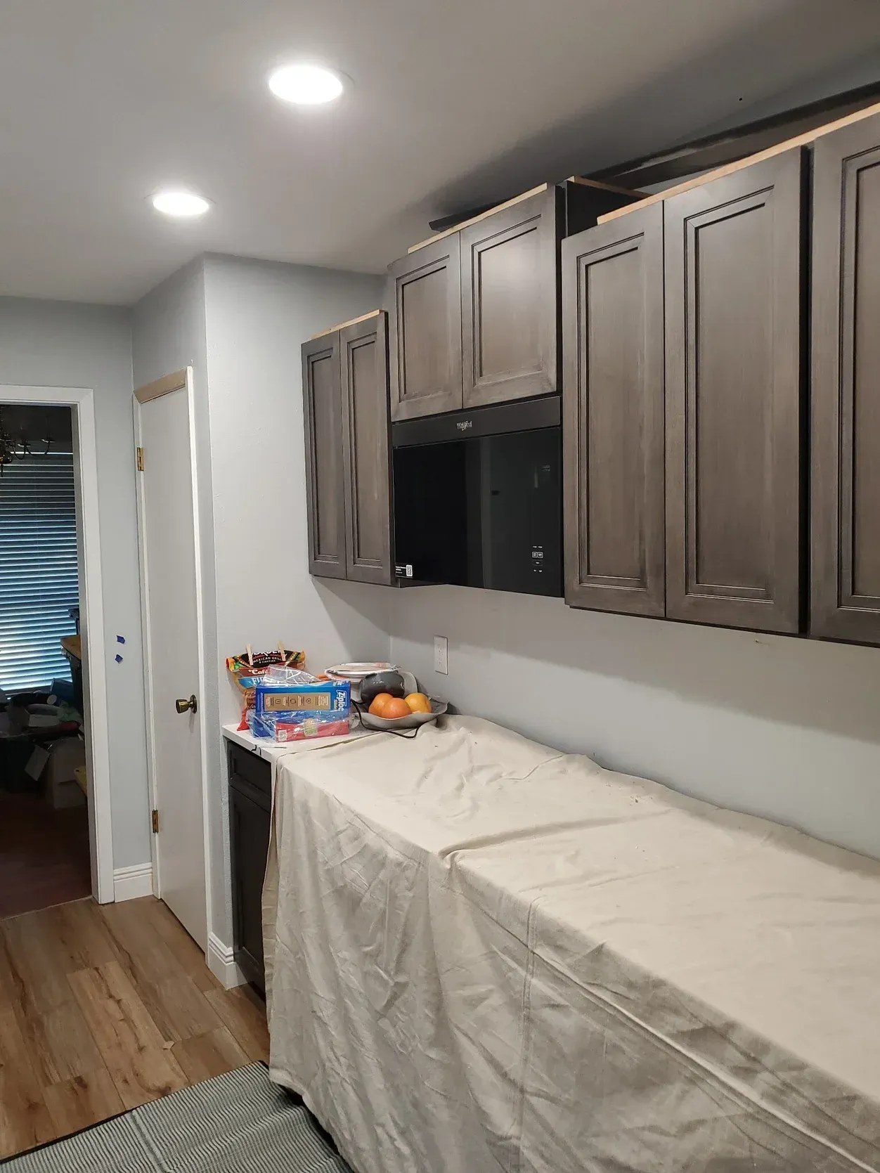 Ladder against a decaying tree trunk, tools attached, under a blue sky.