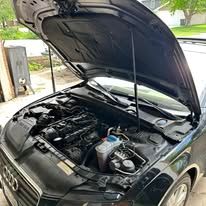 Black car engine with the hood open getting ready to get towed to Huskies Towing & Auto 