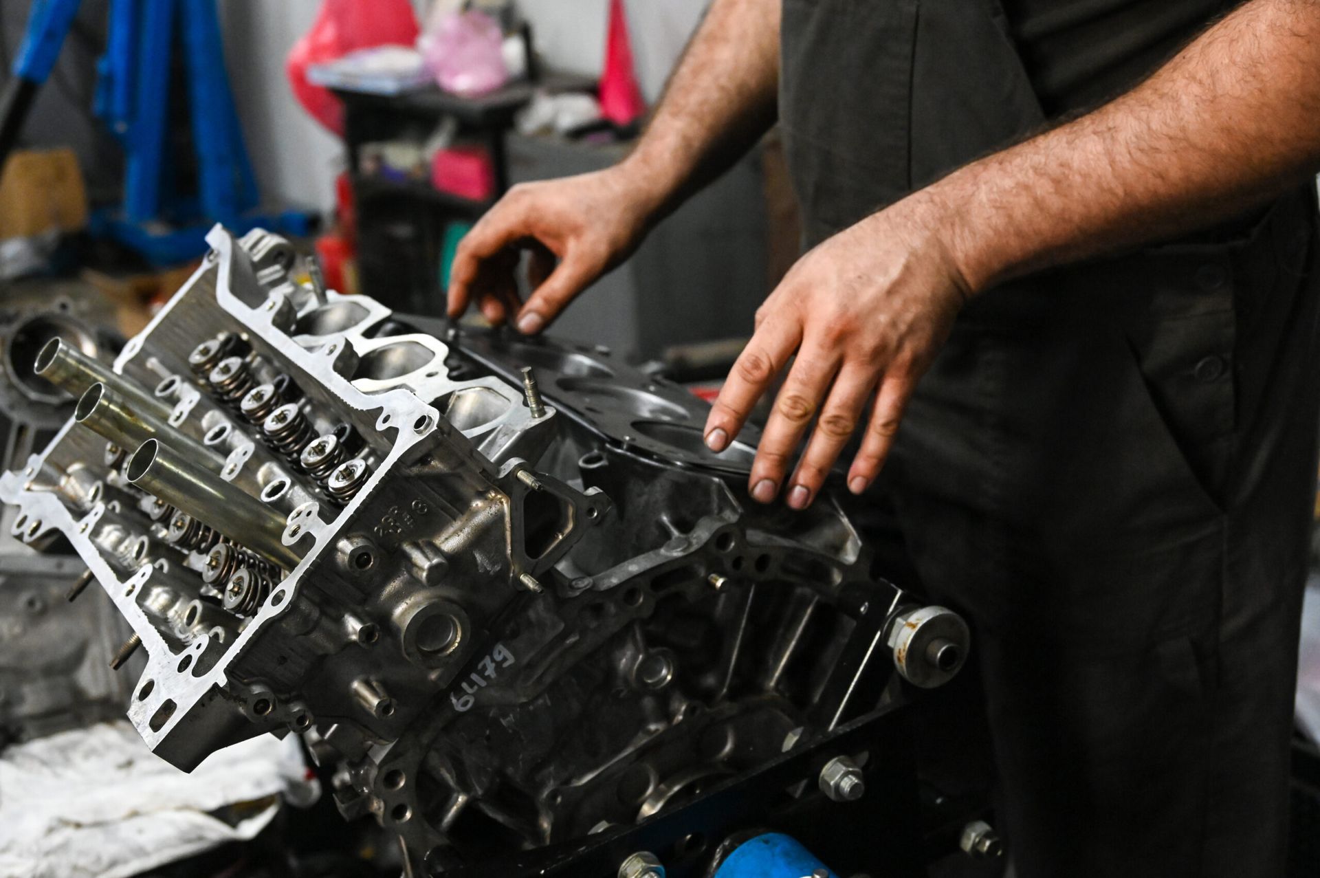 Mechanic working on an engine block at Huskies Towing and Auto garage. Hands are placing a gasket.
