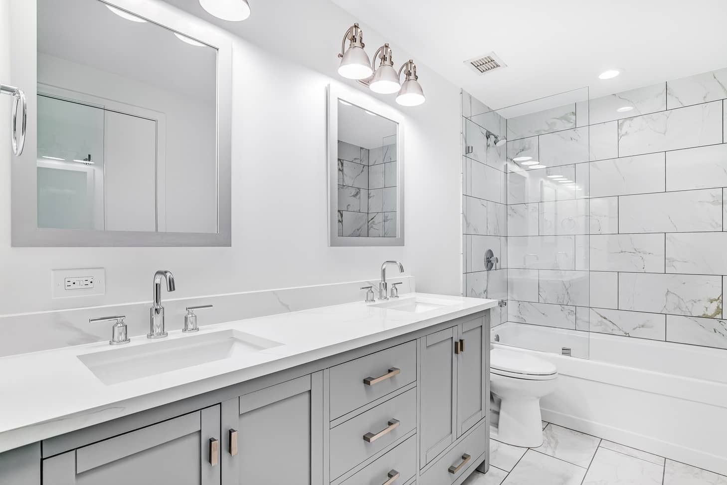 Bathroom with gray vanity, white countertop, two mirrors