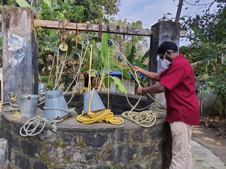 A man wearing a mask is working on a well.