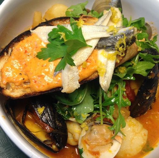 A close up of a bowl of food with fish and vegetables