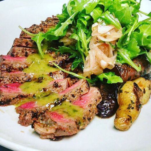 A white plate topped with a steak and vegetables.