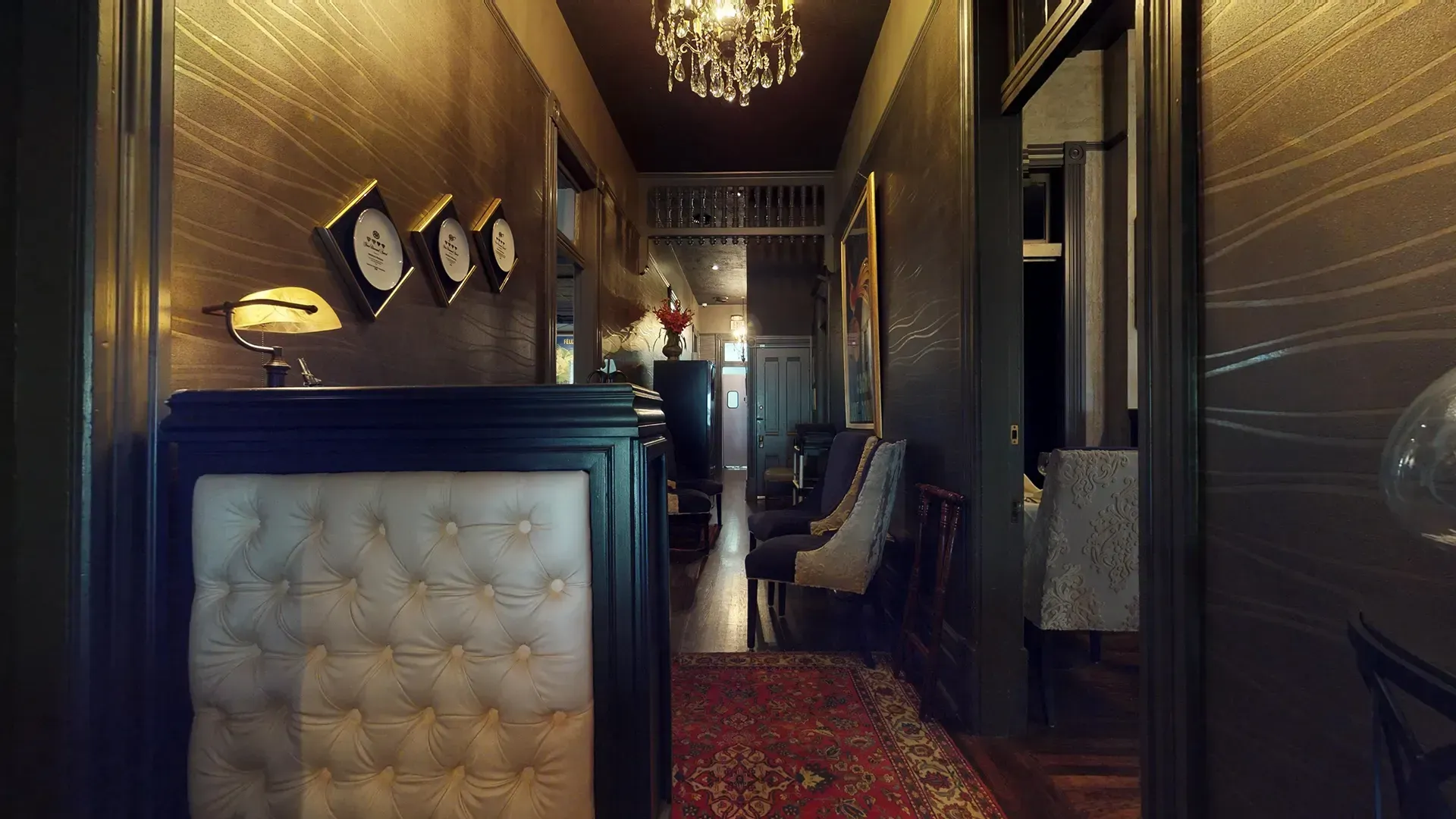 A long hallway with a chandelier hanging from the ceiling.
