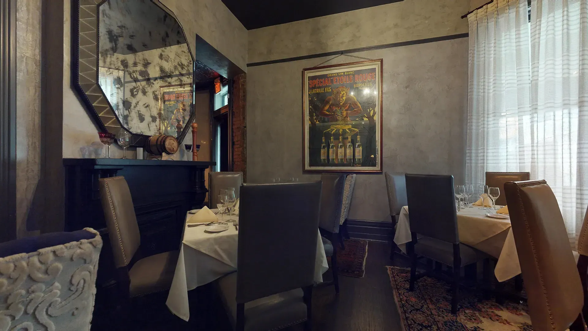 A dining room with tables and chairs and a poster on the wall.
