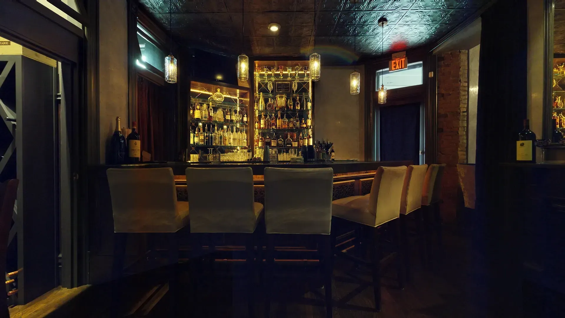 A bar with a lot of chairs and bottles on it