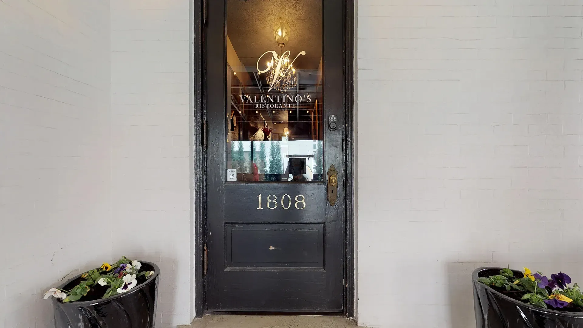 A black door with a glass window and the number 1808 on it.