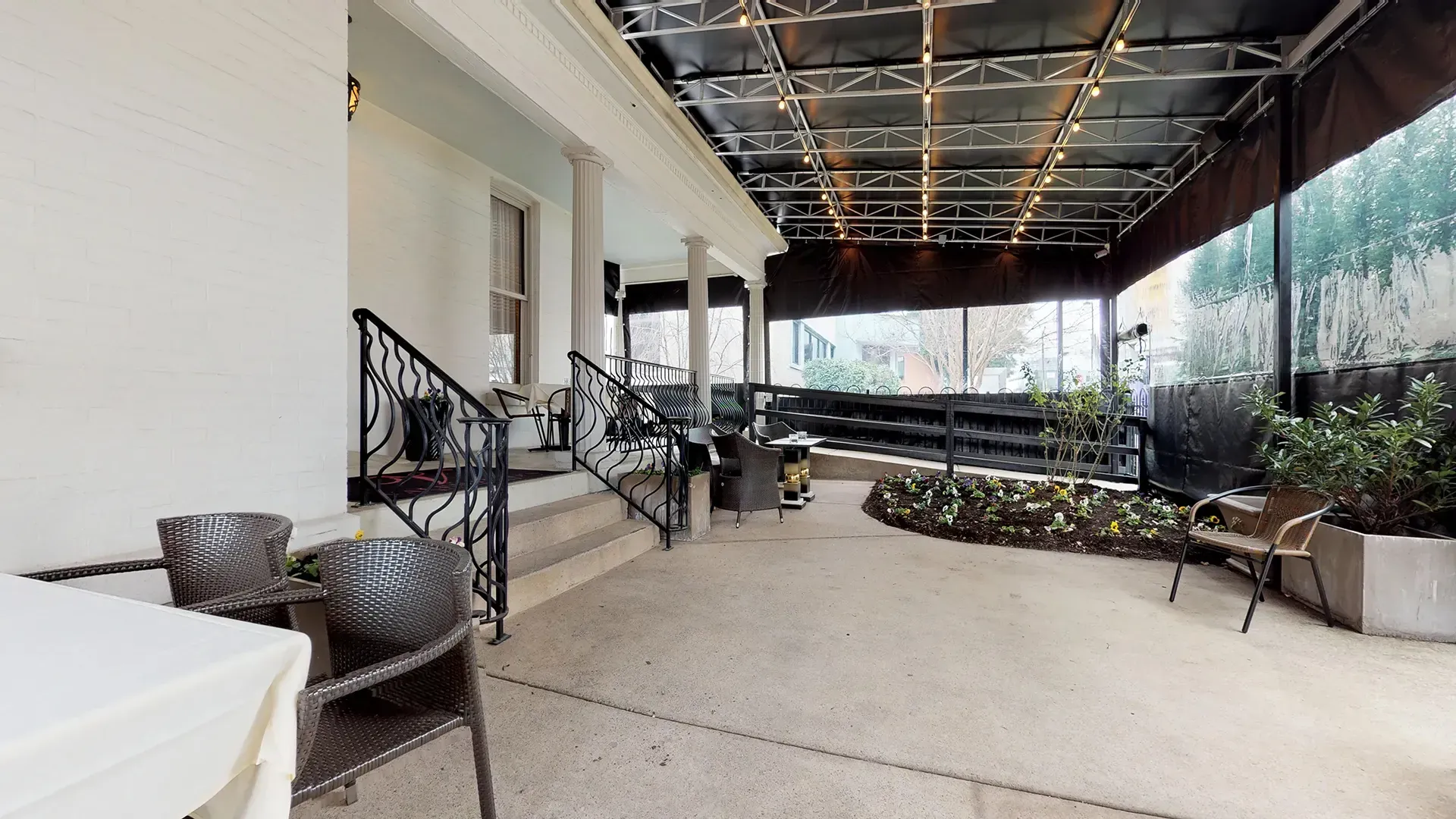 A patio with a table and chairs in front of a building.