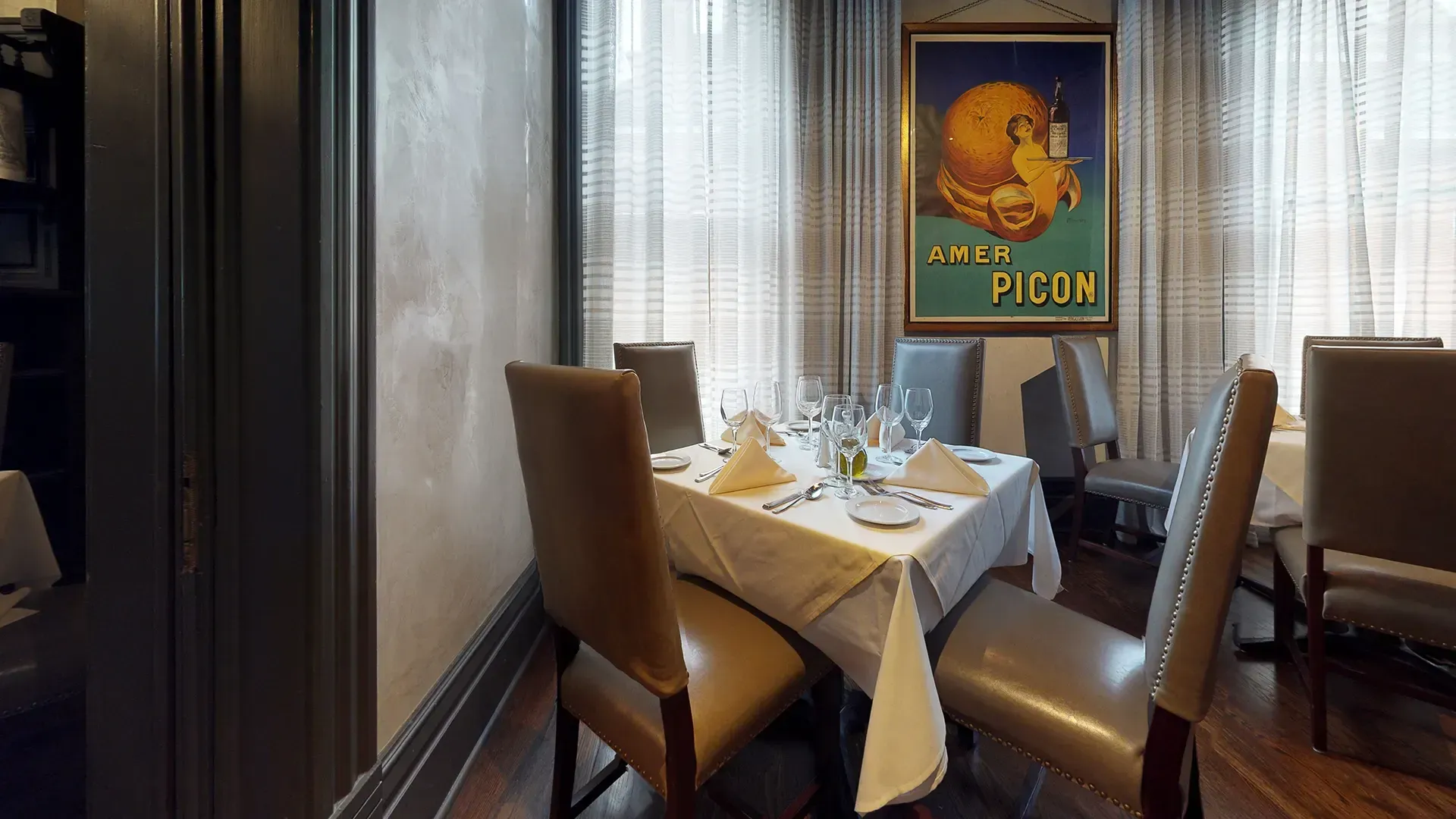 A dining room with a table and chairs and a poster on the wall that says figun
