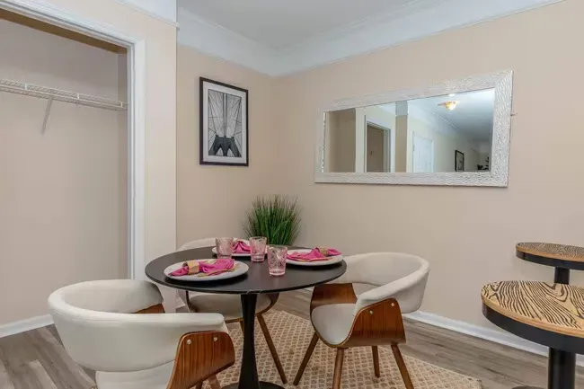 Dining area with round table, four chairs, mirror, and decorative items at Quarry in Columbus, OH.