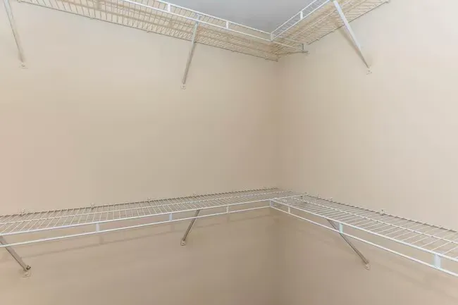 Empty walk-in closet with wire shelving on beige walls at Quarry in Columbus, OH.