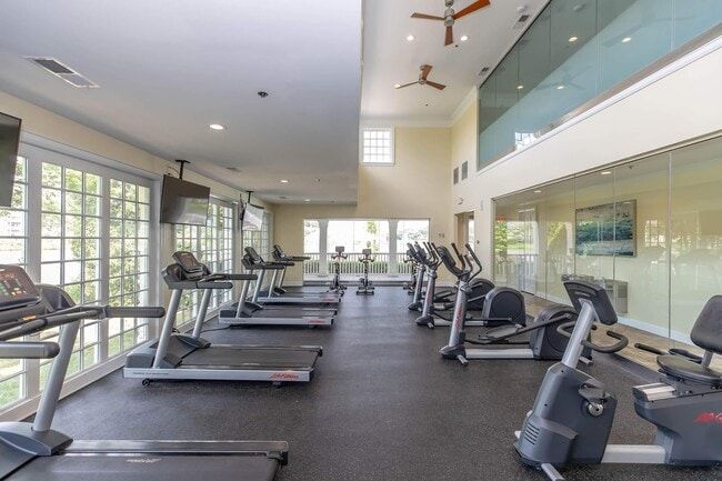 A gym with treadmills, stationary bikes, large windows, and a mezzanine level at Quarry in Columbus, OH.
