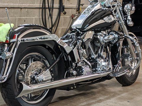 A black and chrome harley davidson motorcycle is parked in a garage.