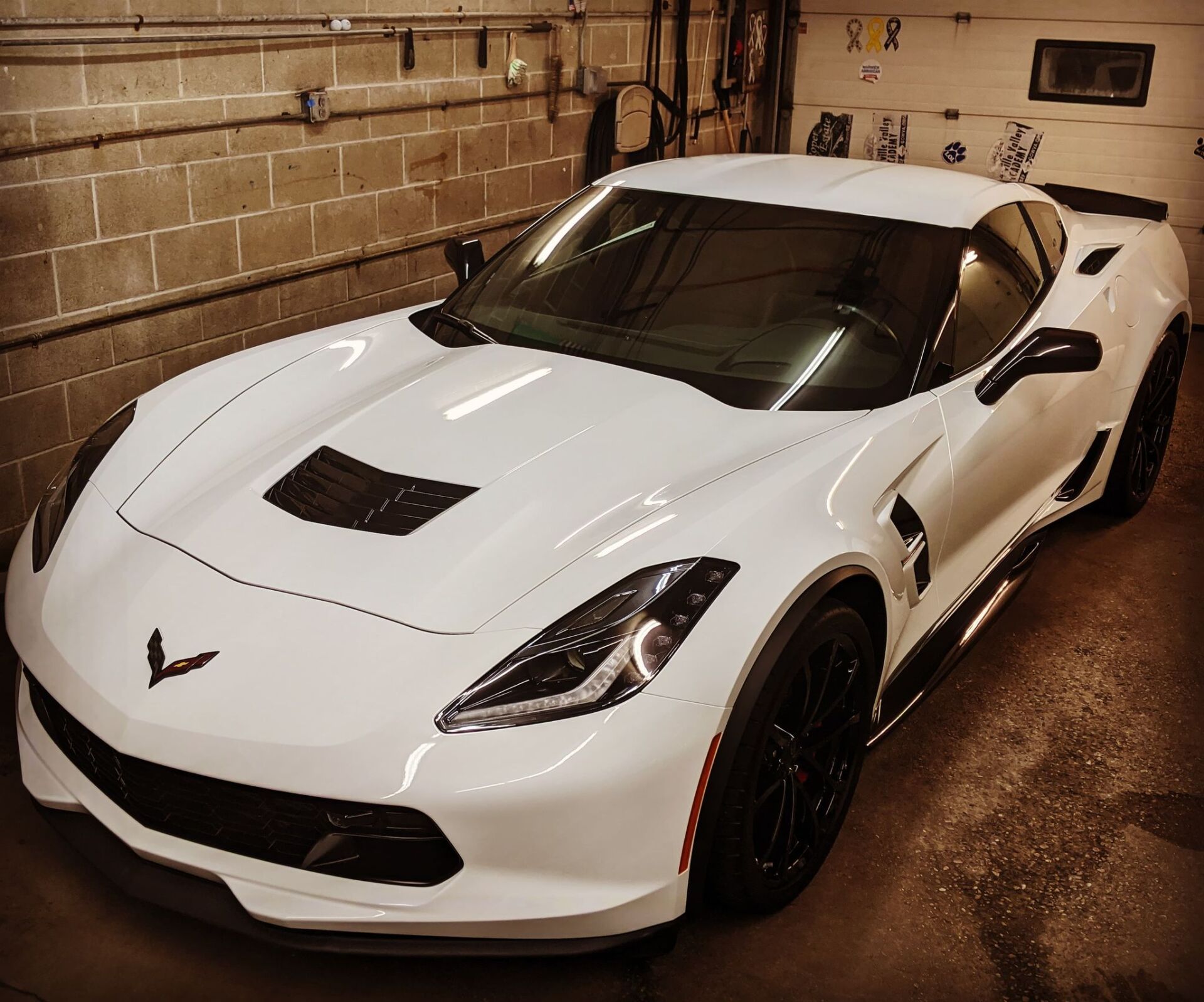 A white corvette sports car is parked in a garage