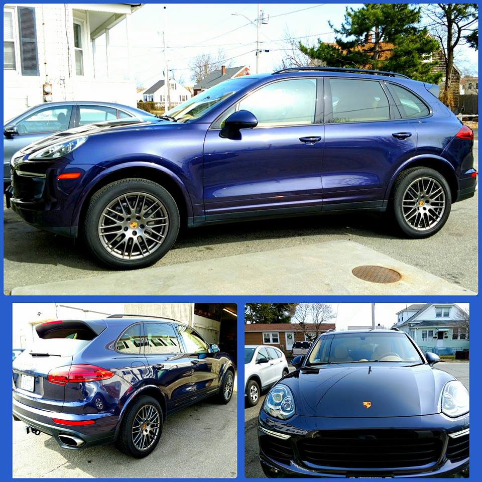 A blue porsche cayenne is parked in a parking lot