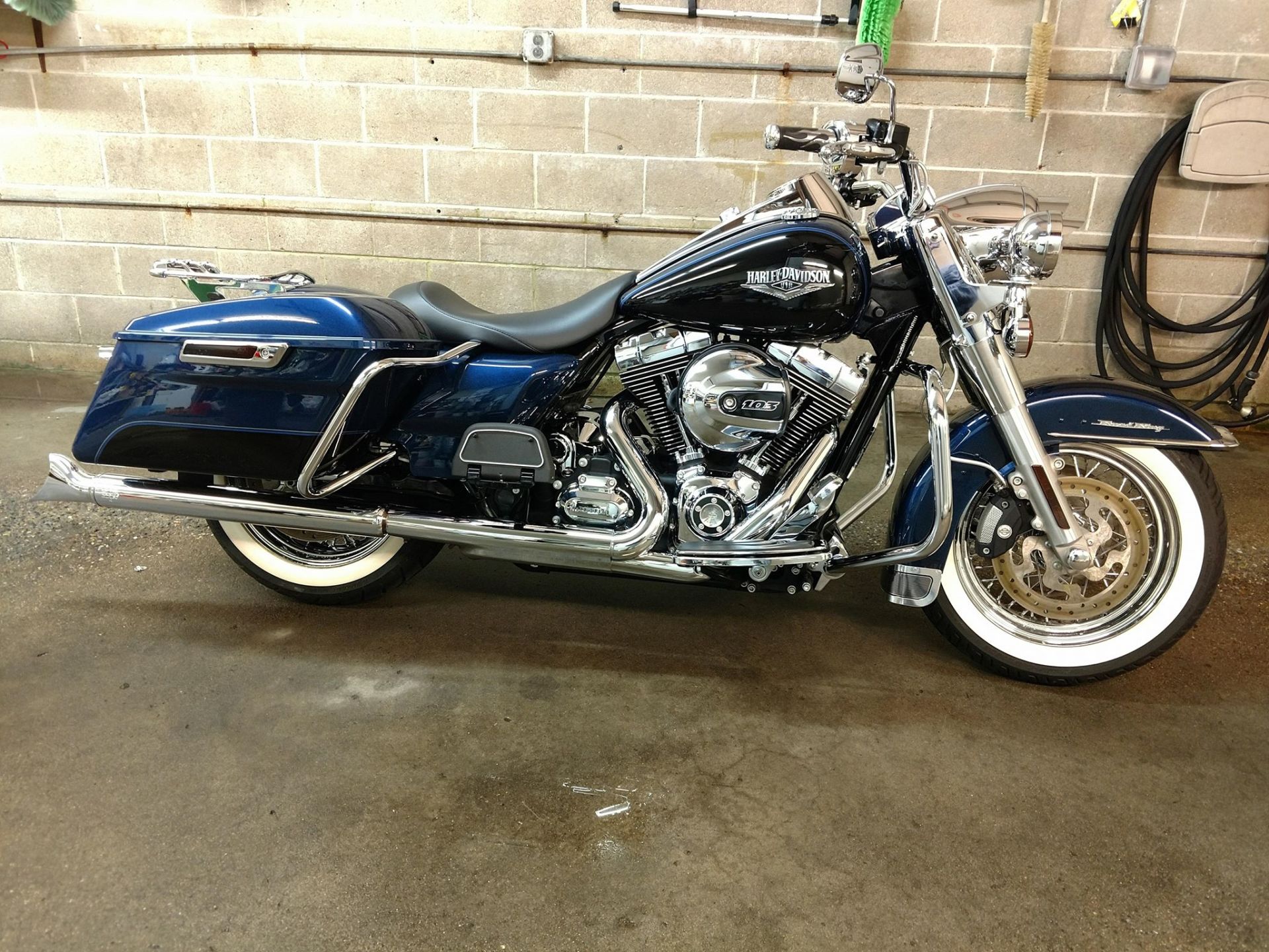 A blue harley davidson motorcycle is parked in a garage.