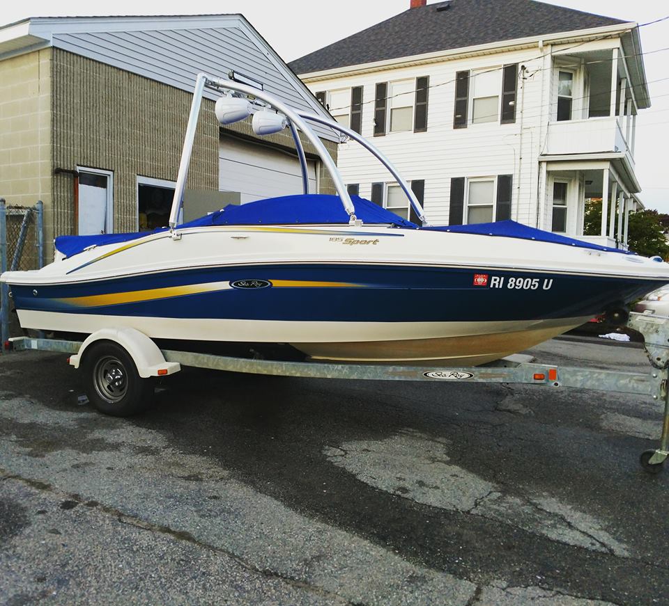 A blue and white boat on a trailer with a license plate that says rv 8883 d