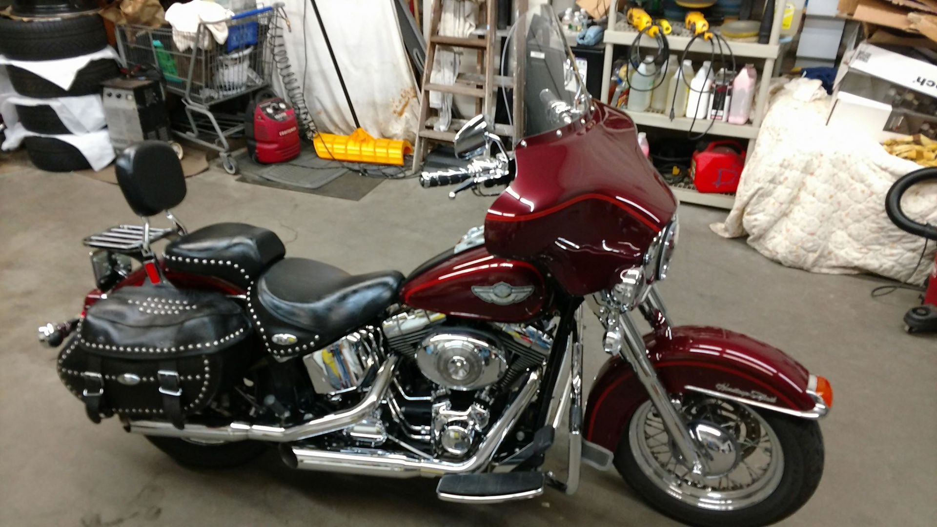 A red harley davidson motorcycle is parked in a garage.