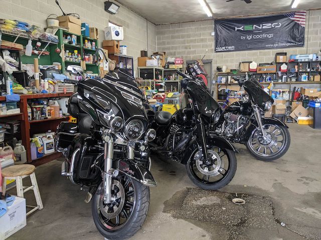 Three harley davidson motorcycles are parked in a garage.