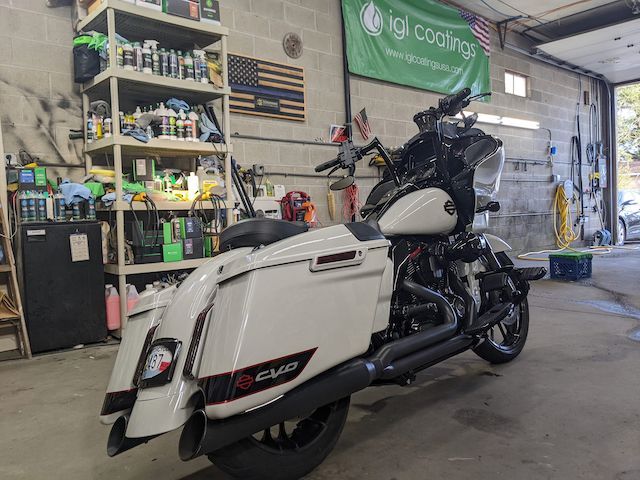A white harley davidson motorcycle is parked in a garage.