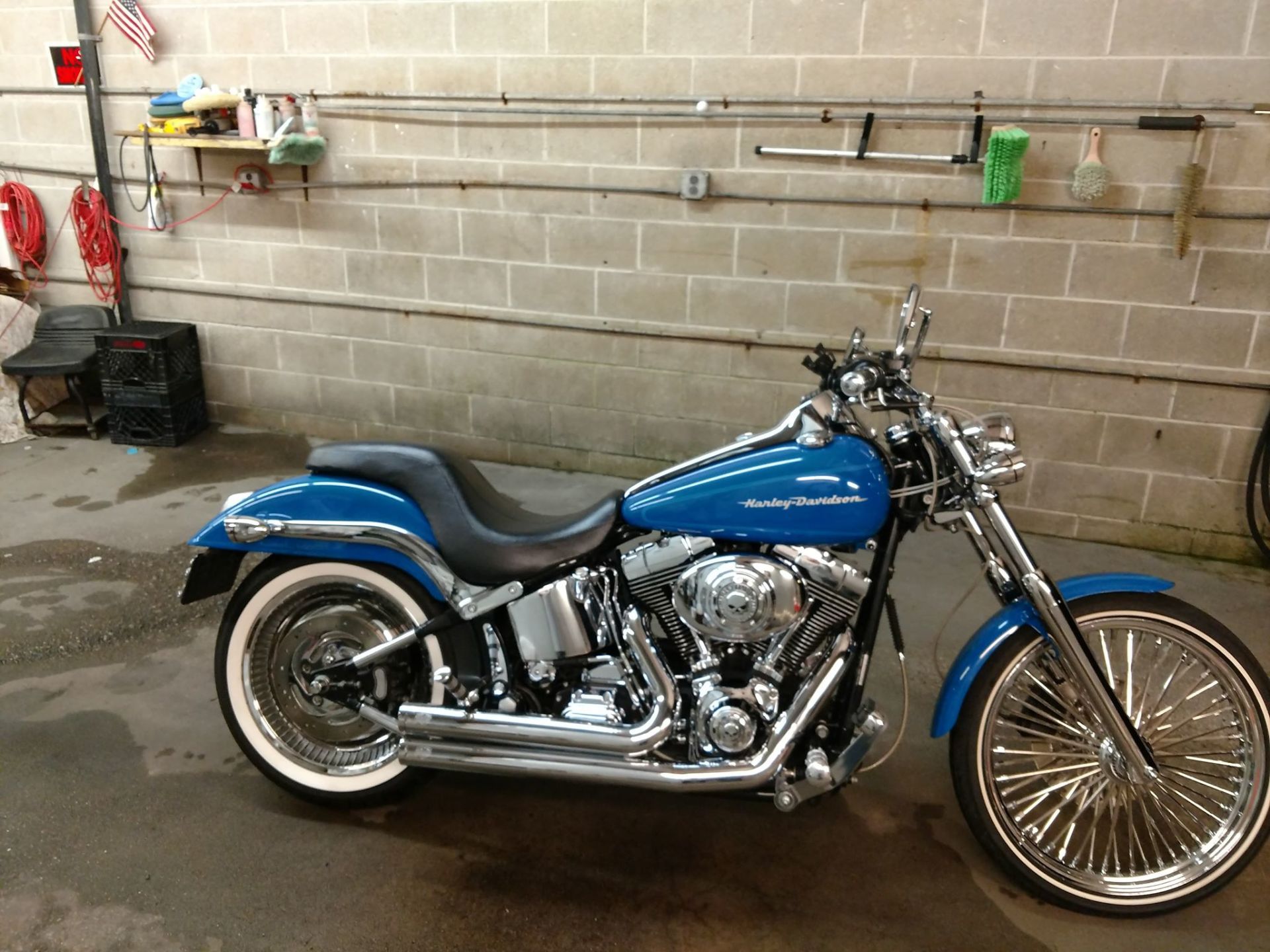 A blue harley davidson motorcycle is parked in front of a brick wall