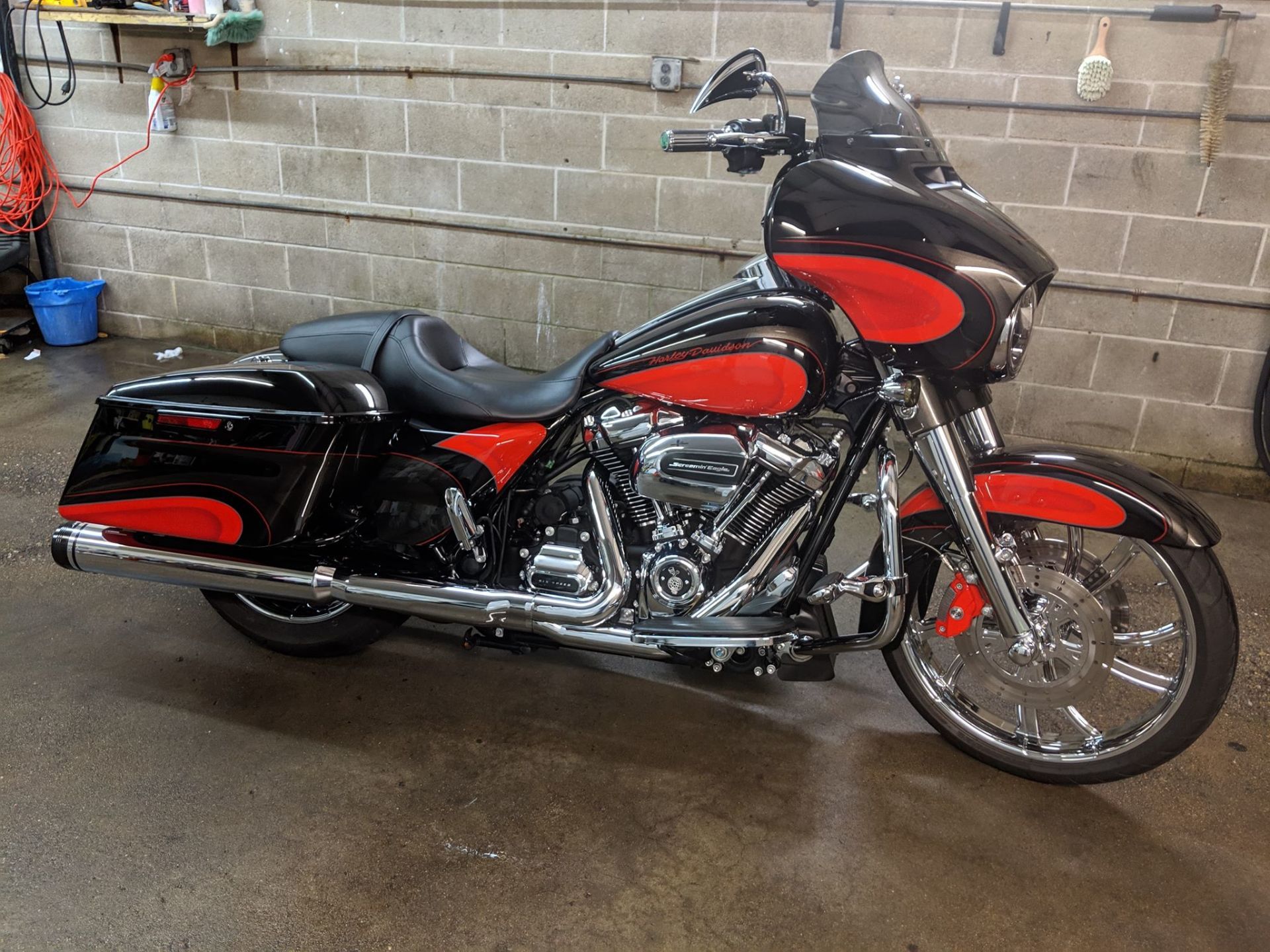 A black and red harley davidson motorcycle is parked in a garage.
