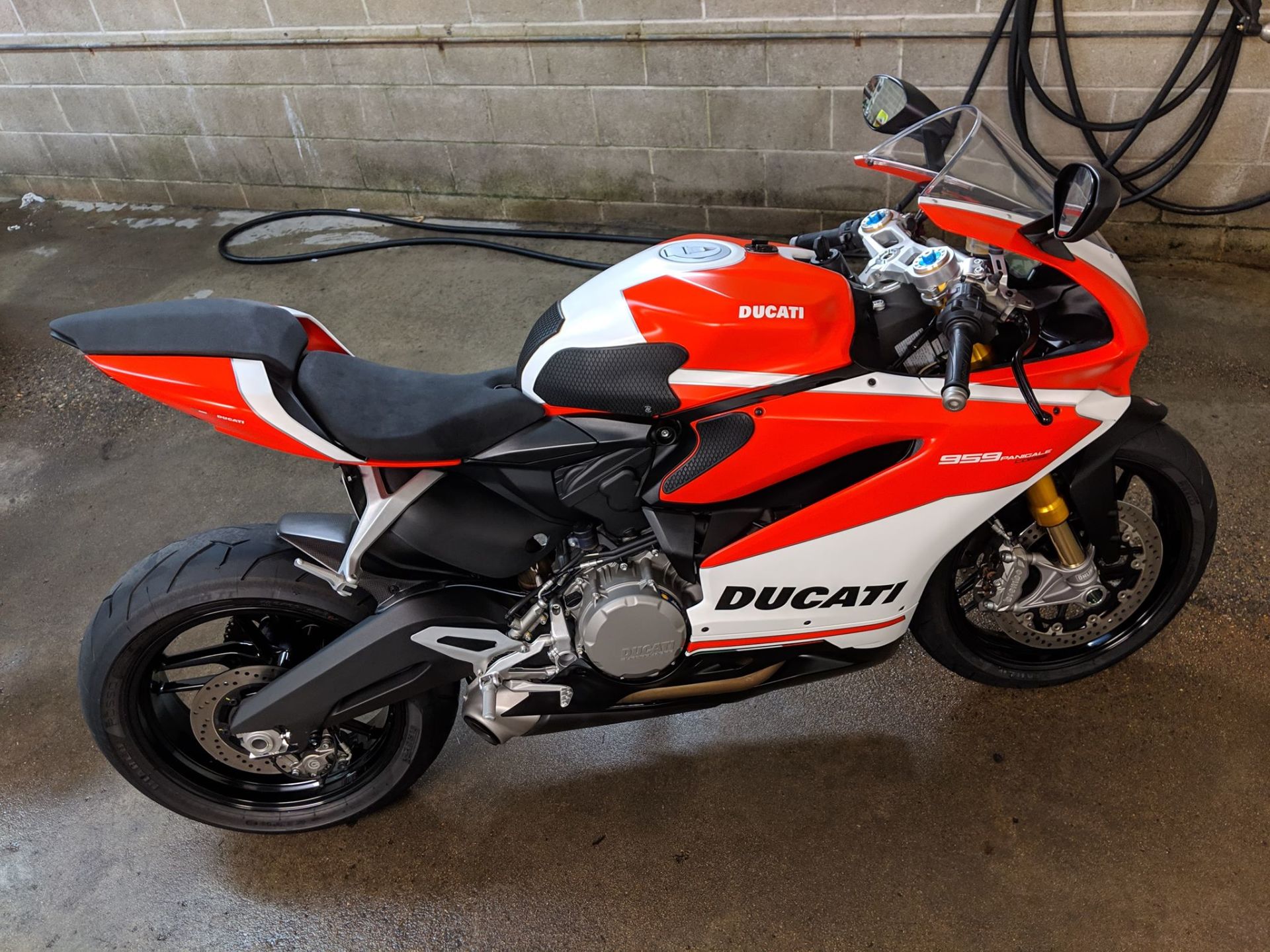 A red and white ducati motorcycle is parked in a parking lot
