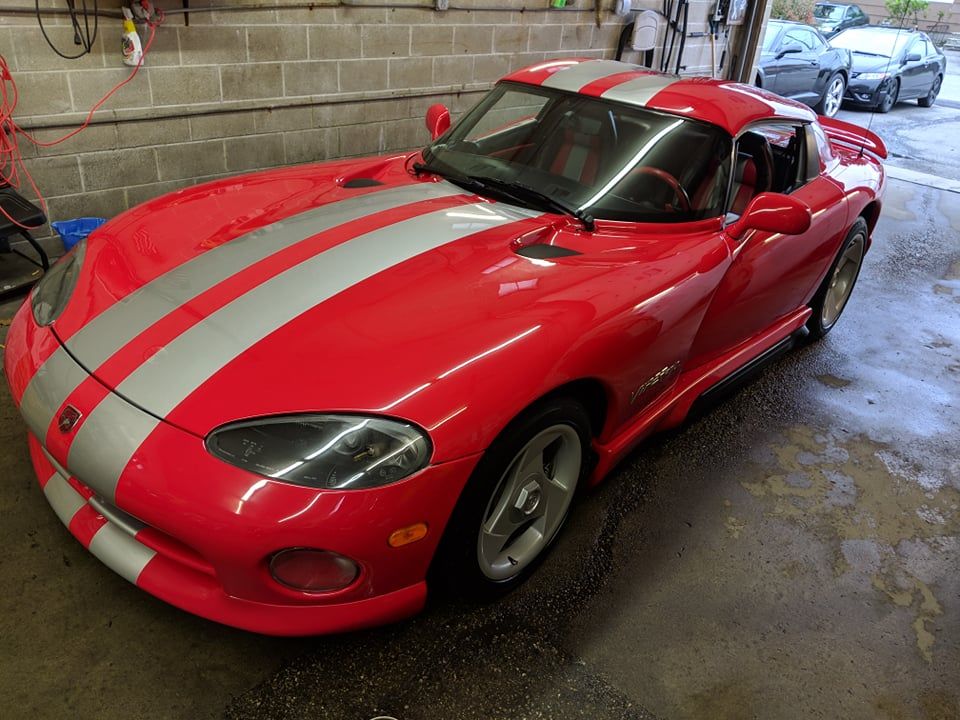 A red dodge viper is parked in a garage
