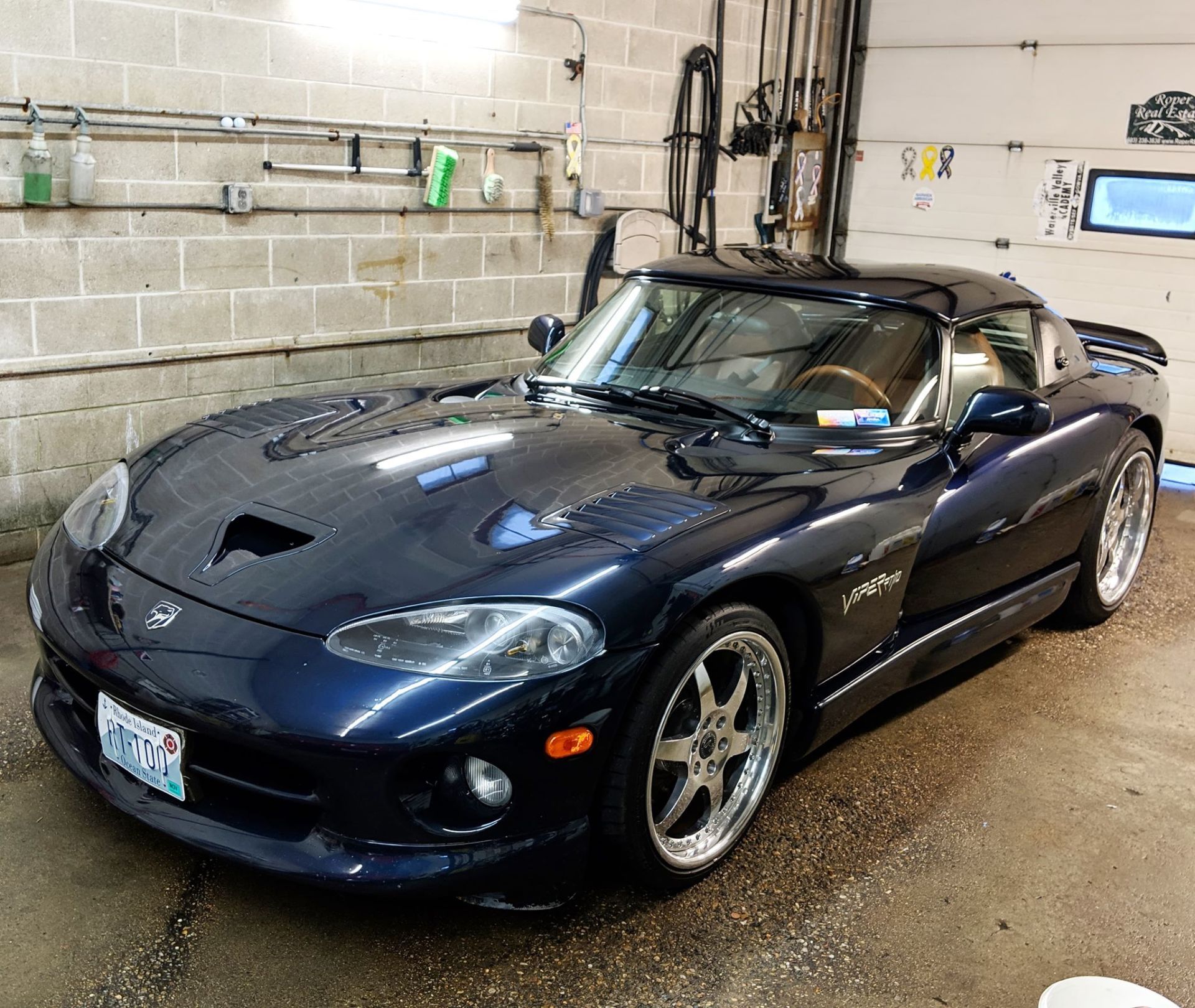 A blue dodge viper is parked in a garage
