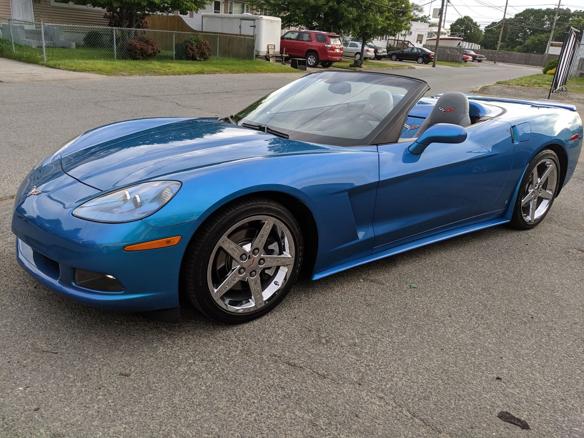 A blue sports car is parked on the side of the road.