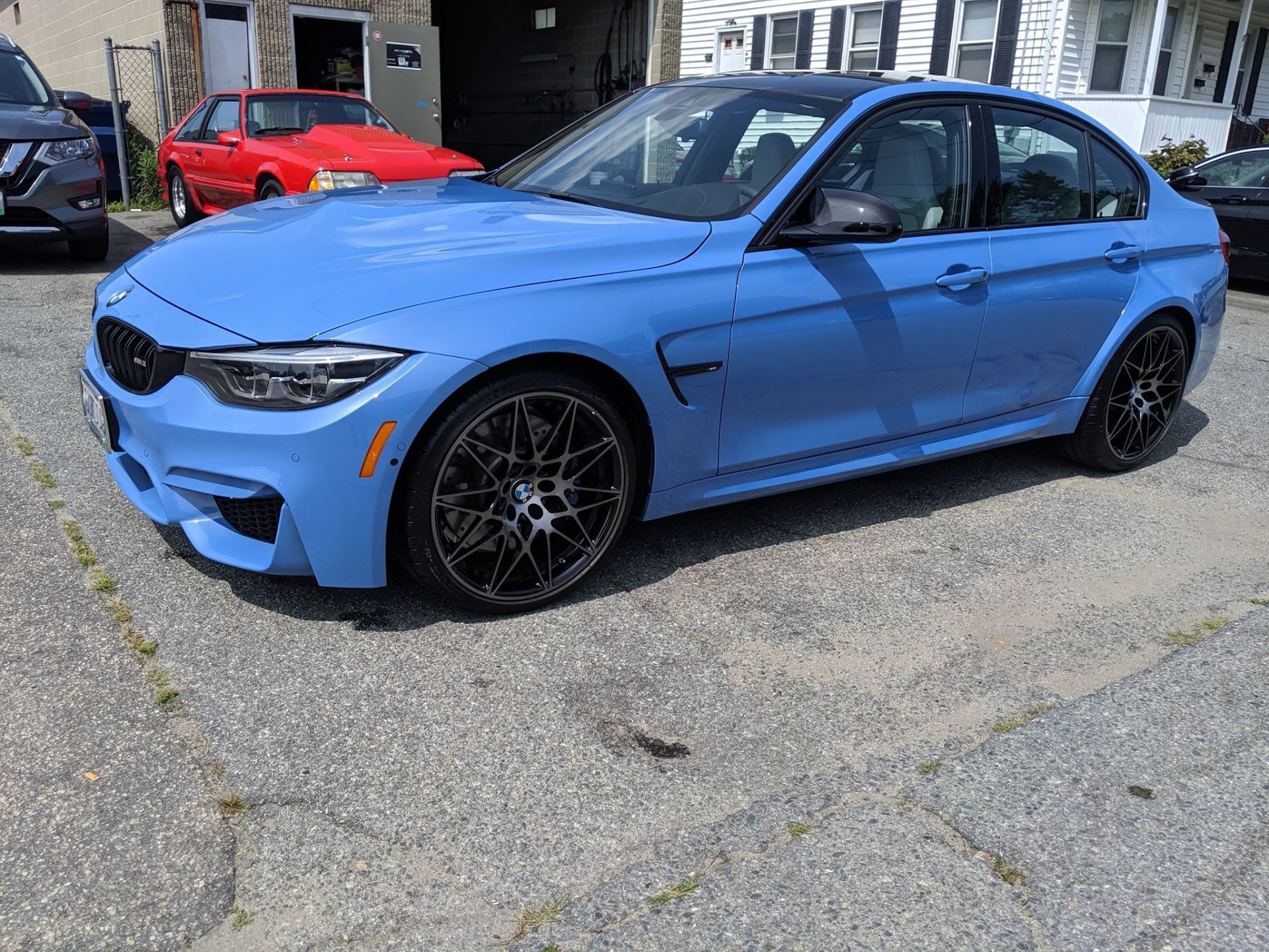 A blue bmw m3 is parked in a parking lot.