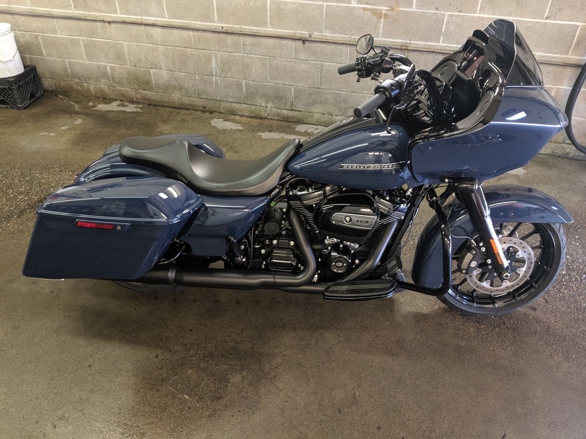 A blue harley davidson road glide is parked in a garage.