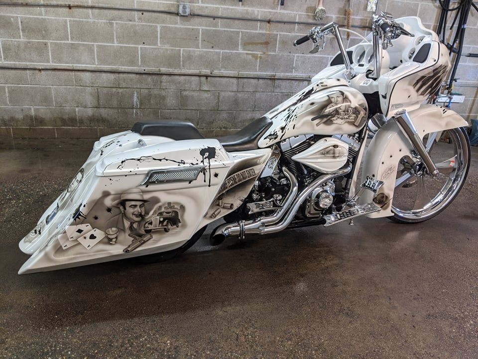 A white motorcycle is parked in front of a brick wall