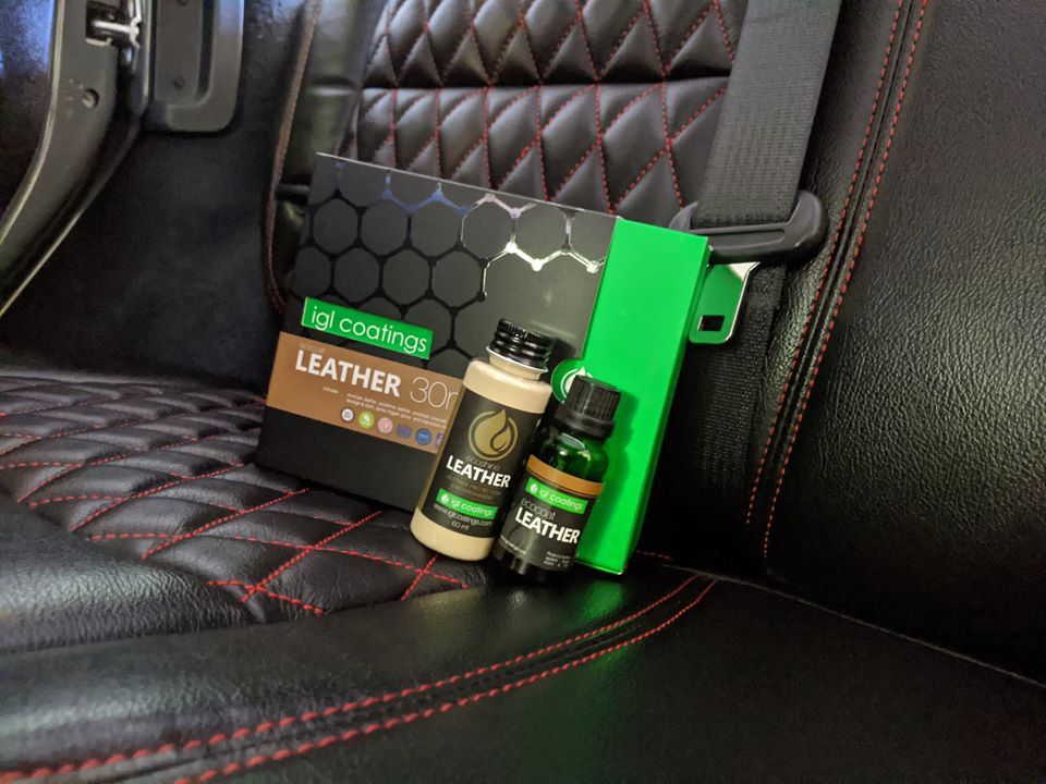 A bottle of leather polish is sitting on the back seat of a car.